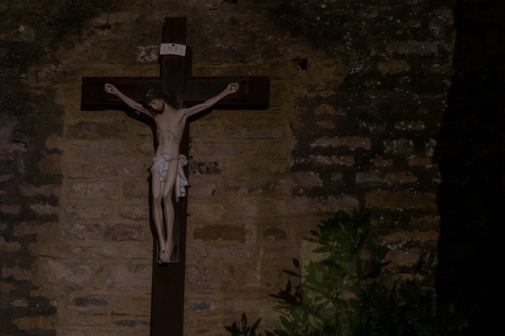 An image in a golden light of a woman superimposed on a church altar in front of an arched window. 