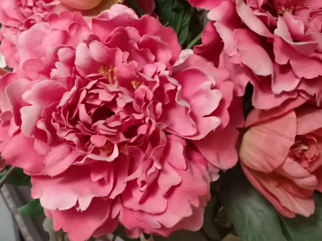 Fourth of four photographs forming a sequence. This one is of a detail of artificial pink flowers.
