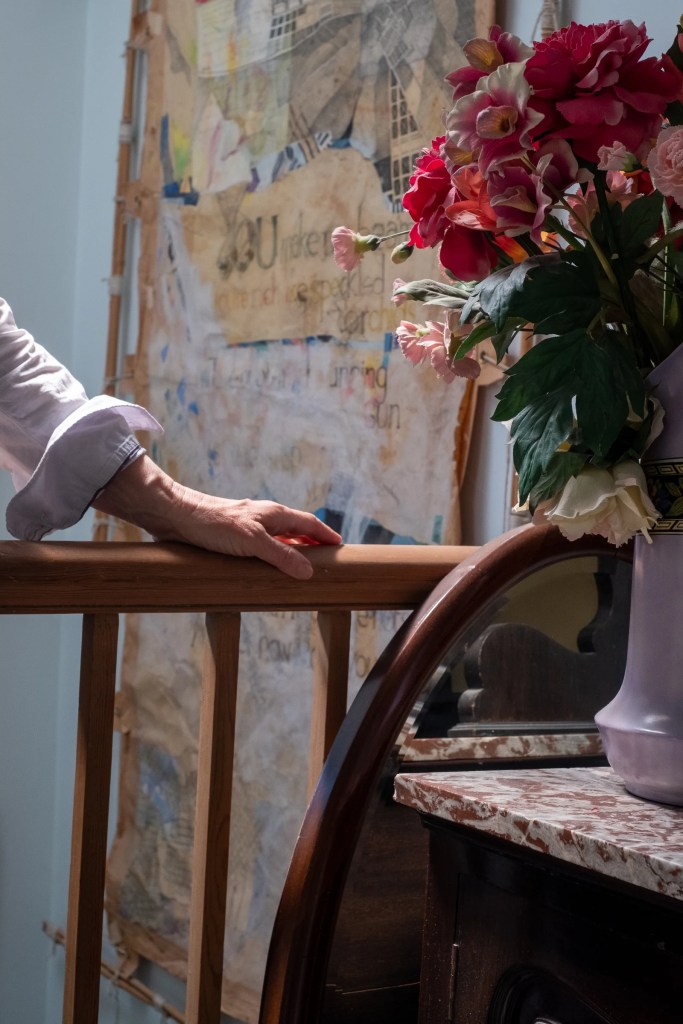 Four photographs show a woman with her hand on a balustrade as she looks back toward the camera and then proceeds to walk down a flight of stairs.