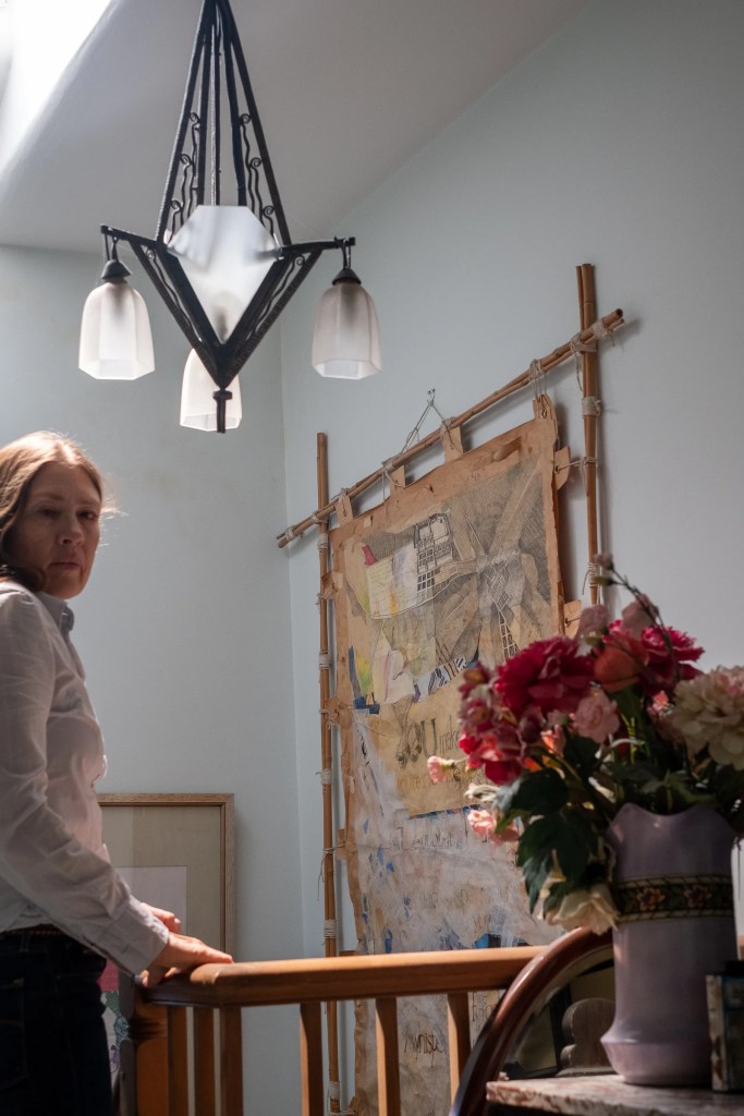 Four photographs show a woman with her hand on a balustrade as she looks back toward the camera and then proceeds to walk down a flight of stairs.